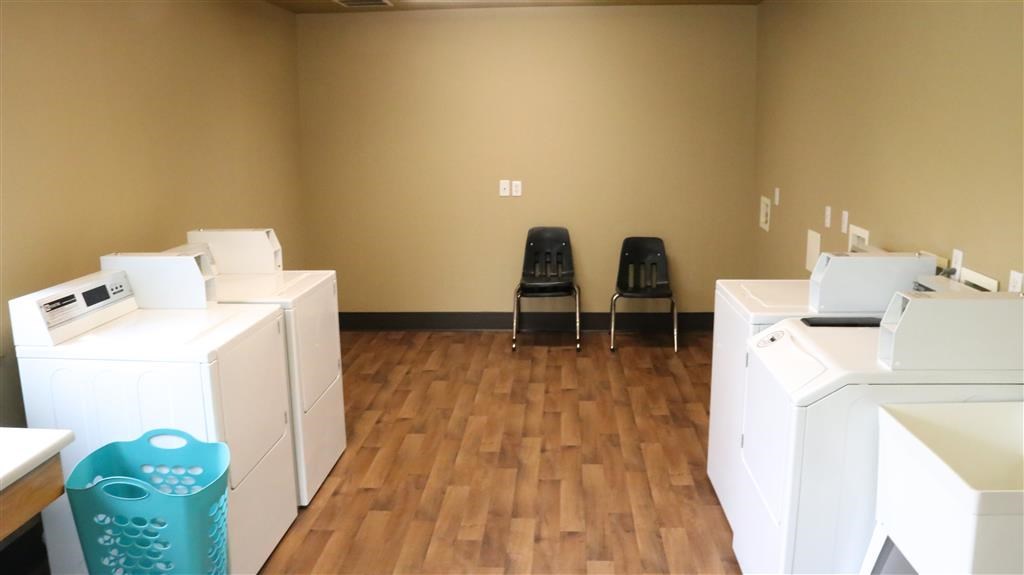 a room filled with washers and dryers and chairs