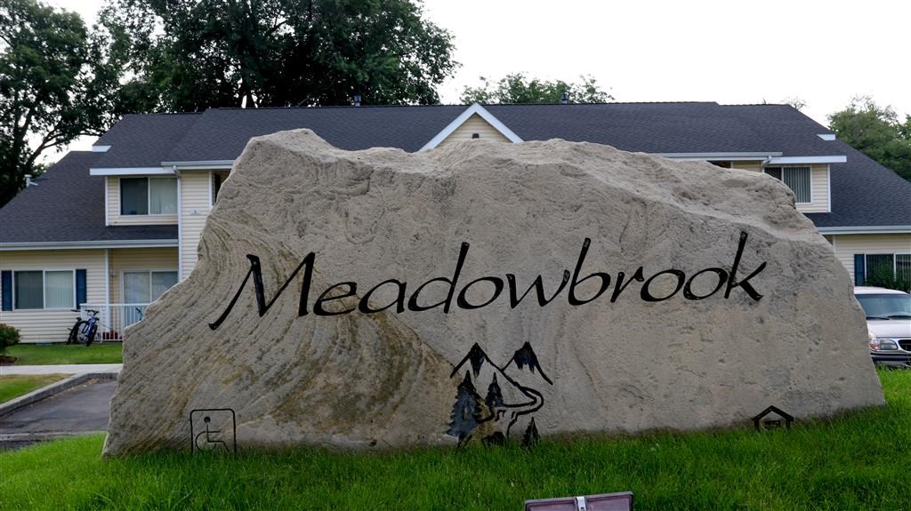 a large rock with the word on it in front of a house