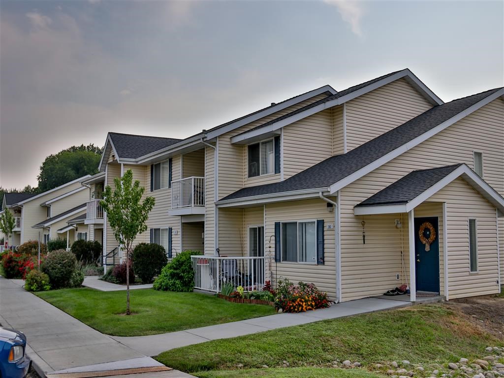 a row of houses with a sidewalk in front of them