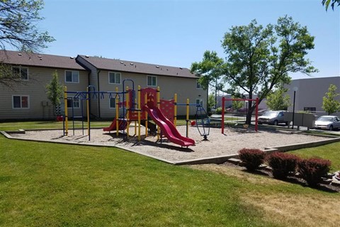 a playground with slides and other toys in front of a building