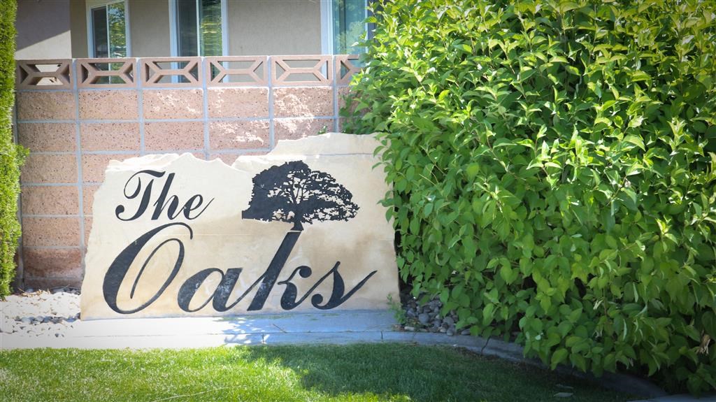 a sign in front of a house that reads the oaks