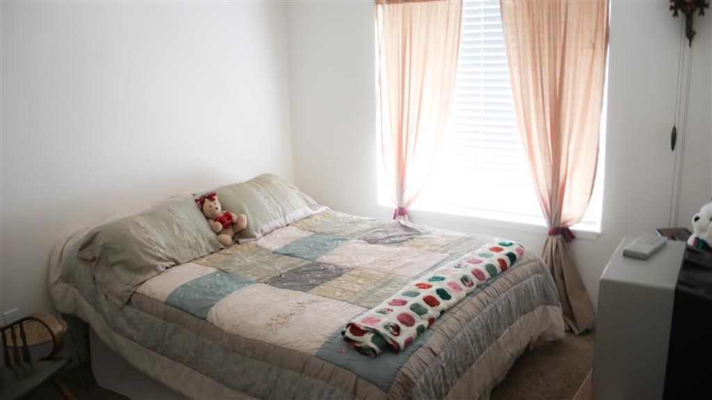 a bedroom with a bed with a quilt on it