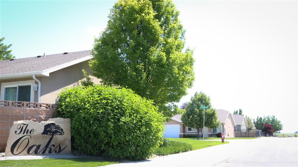 a sign in front of a house that reads the oaks