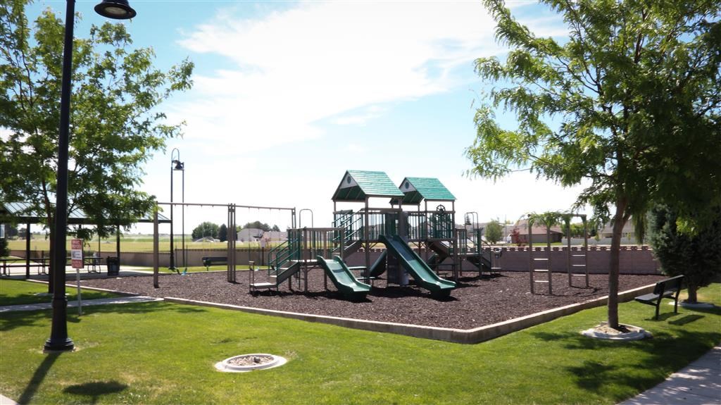 a playground with a set of slides in a park