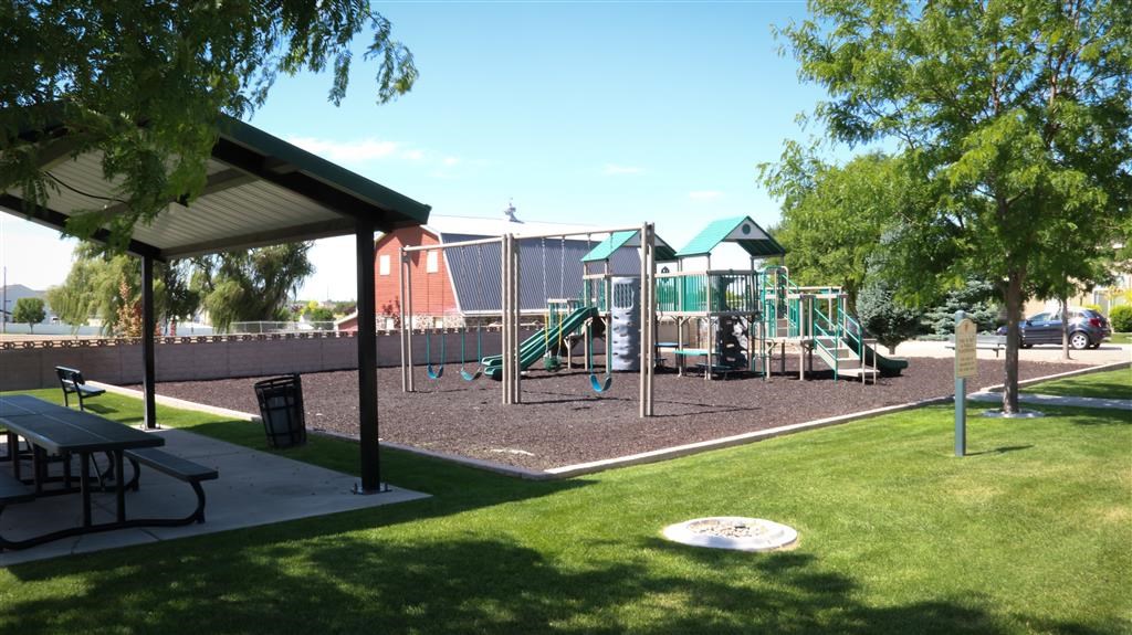 a playground with a picnic table and a swing set