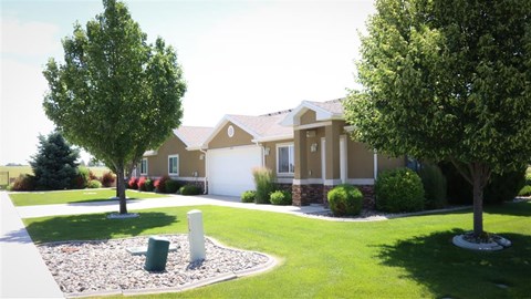 a house with a yard and trees in front of it