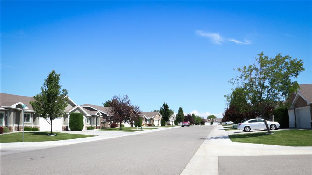 a street of houses in a suburban neighborhood with a car parked