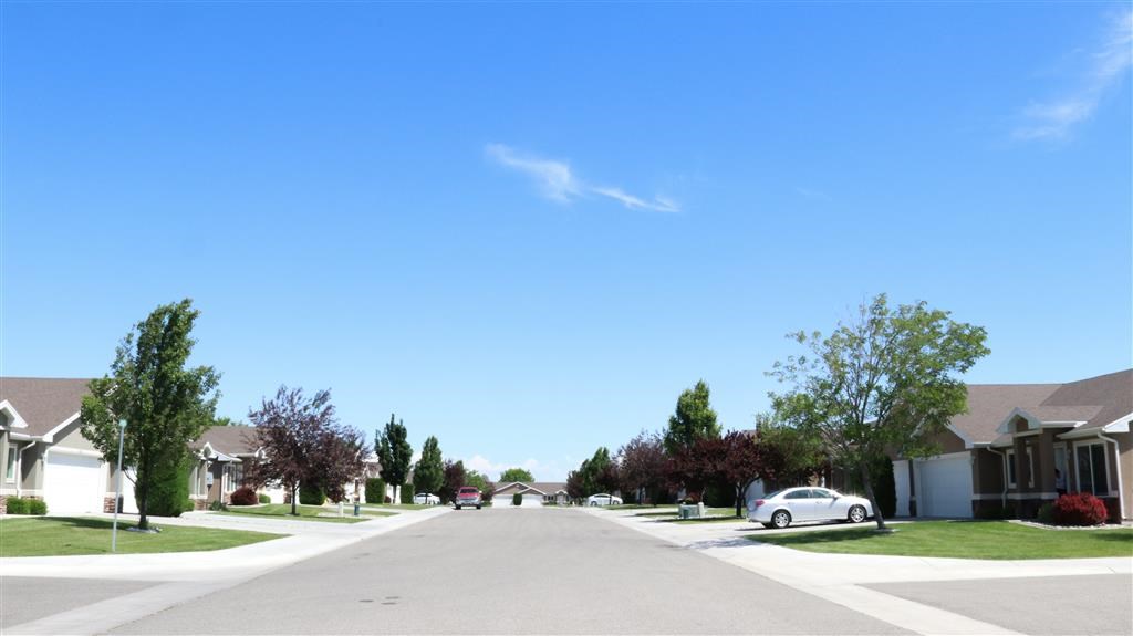 a street in a suburban neighborhood with a car parked on the street