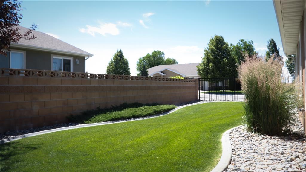 a retaining wall in a yard in front of a house