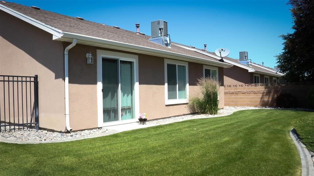 a brown house with a yard and a lawn