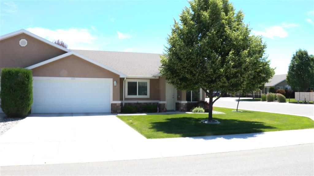 a house with a garage and a tree in front of it