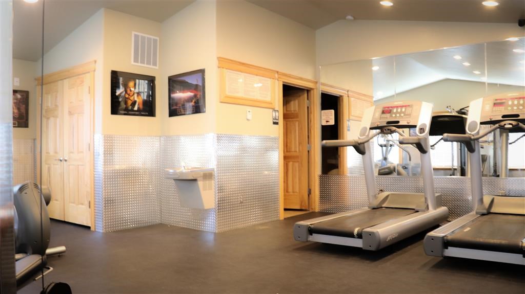 a gym with cardio machines and a toilet