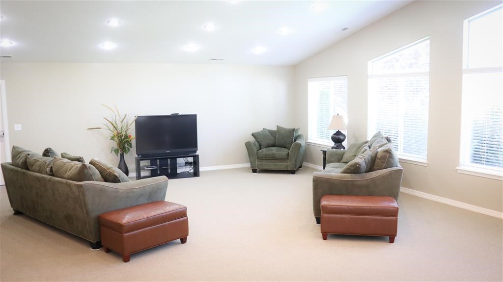 a living room with couches and chairs and a television
