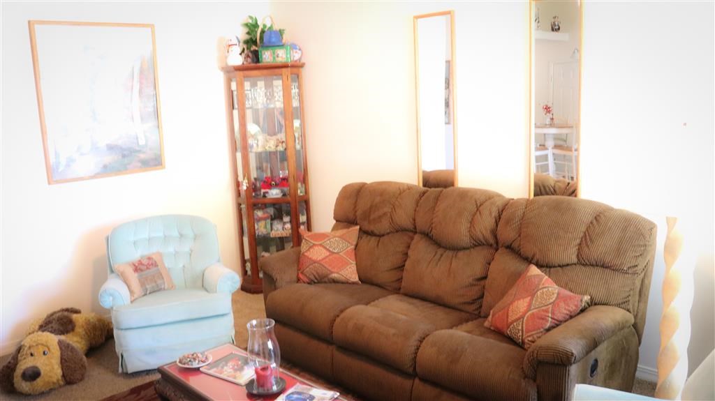 a living room with a brown couch and a blue chair