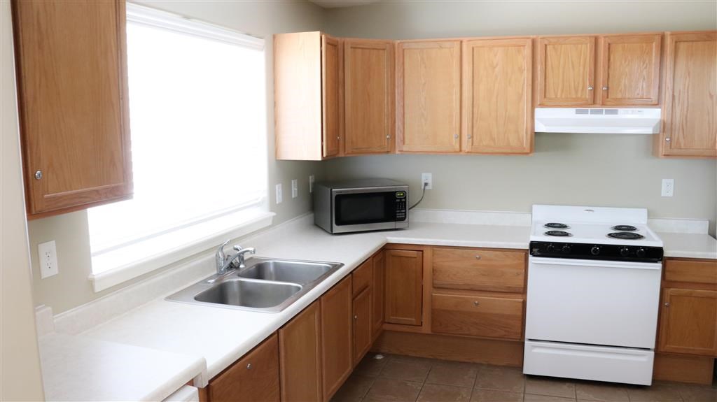 a kitchen with a sink a stove and a window