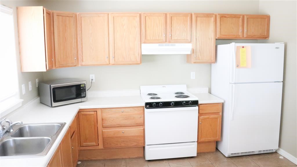 a kitchen with white appliances and wooden cabinets