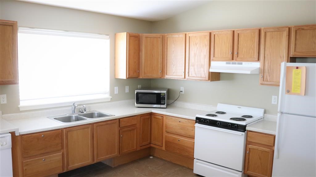 a kitchen with white appliances and wooden cabinets