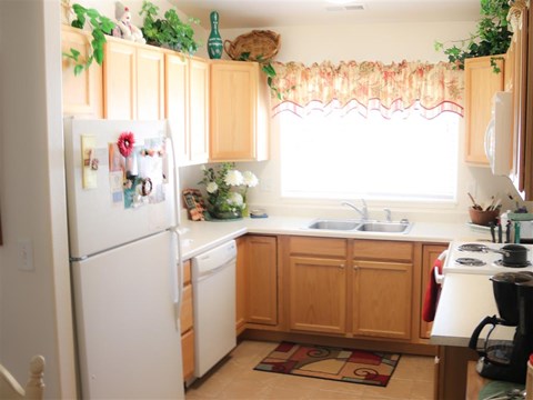 a kitchen with white appliances and wooden cabinets
