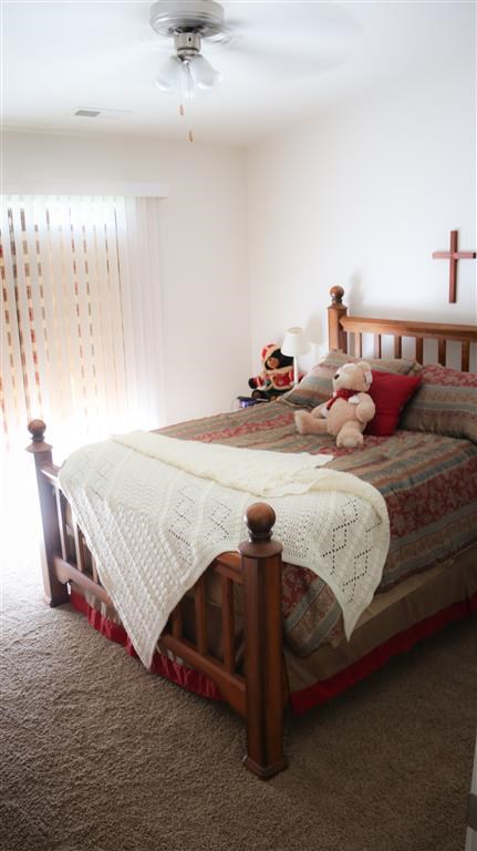 a bedroom with a bed with a teddy bear on it