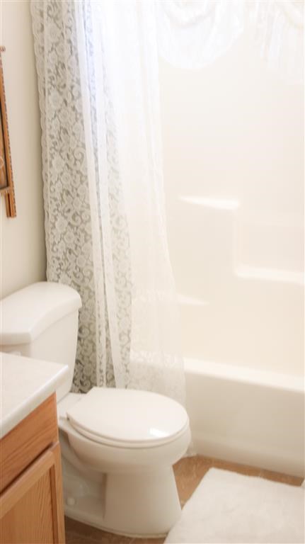 a bathroom with a toilet and a shower curtain