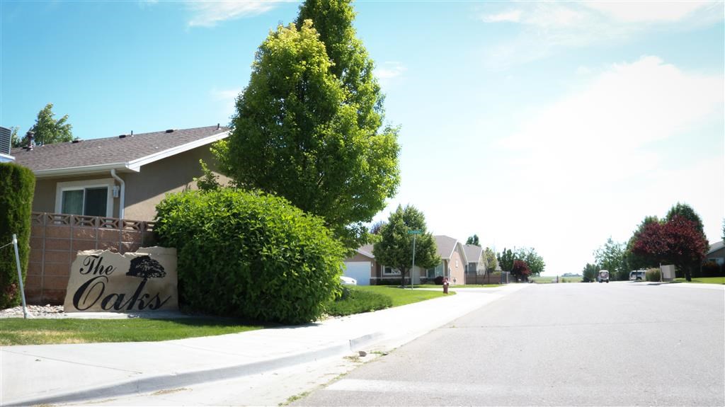 a sign on the side of a street in front of a house