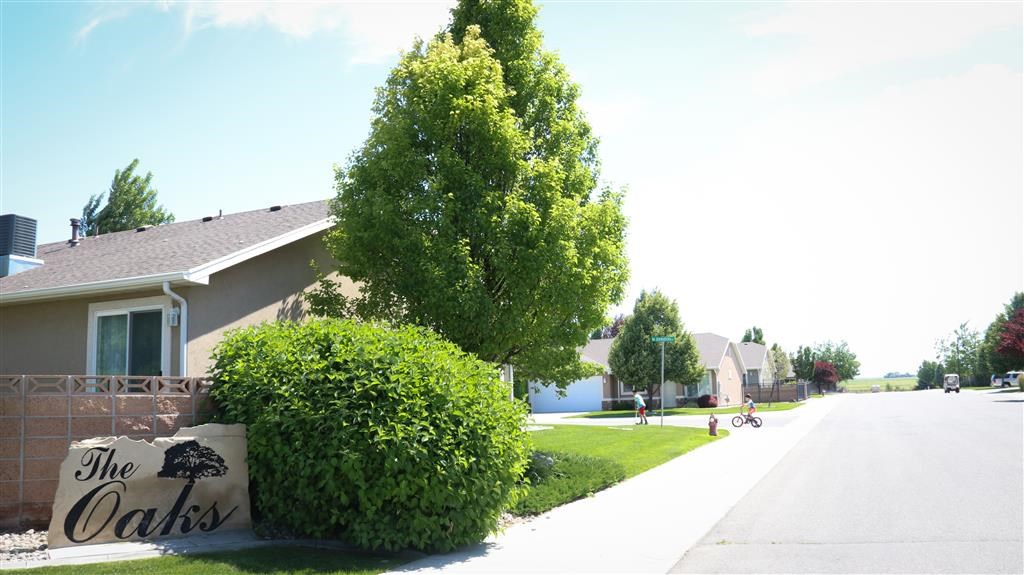 a sign for the oaks in front of a house