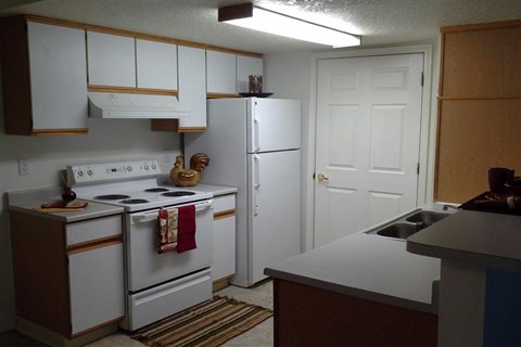 a kitchen with white appliances and a refrigerator