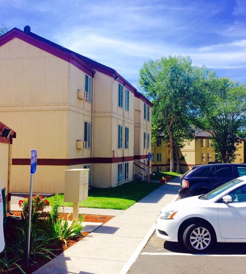 an apartment building with cars parked in front of it
