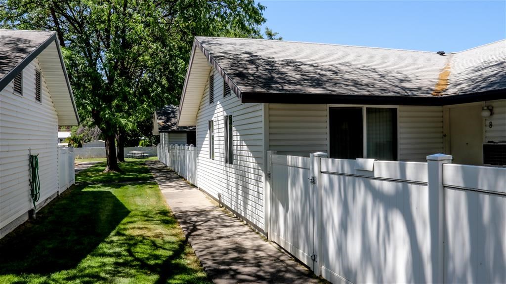 a white house with a white fence and a sidewalk