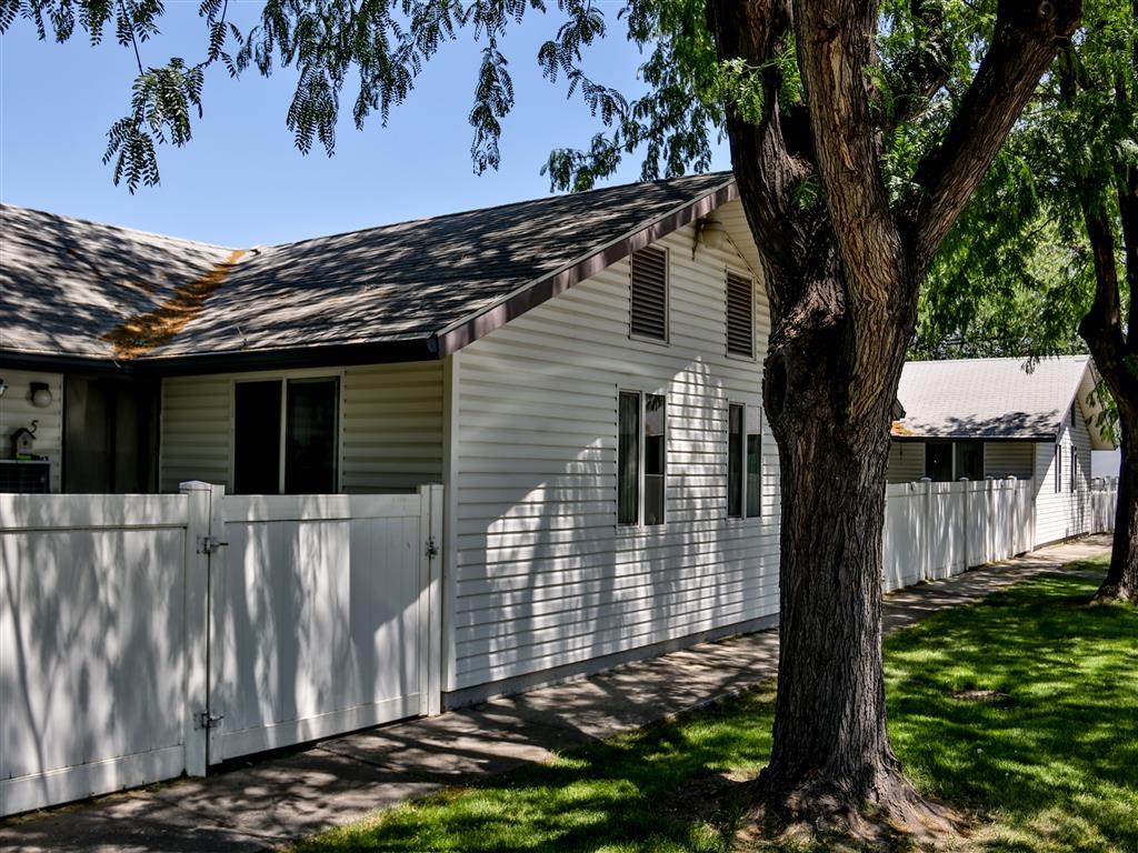 a white house with a white fence and a tree