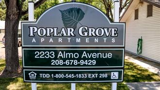 a sign for popular grove apartments in front of a house