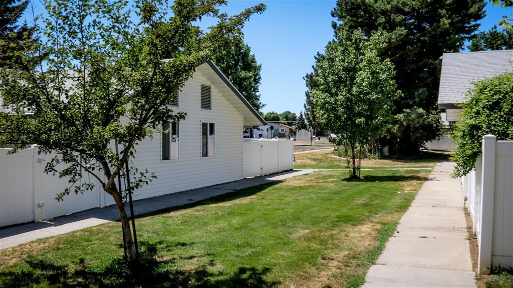 a white house on the side of a sidewalk
