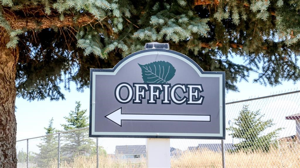 a sign for the office in front of a fence