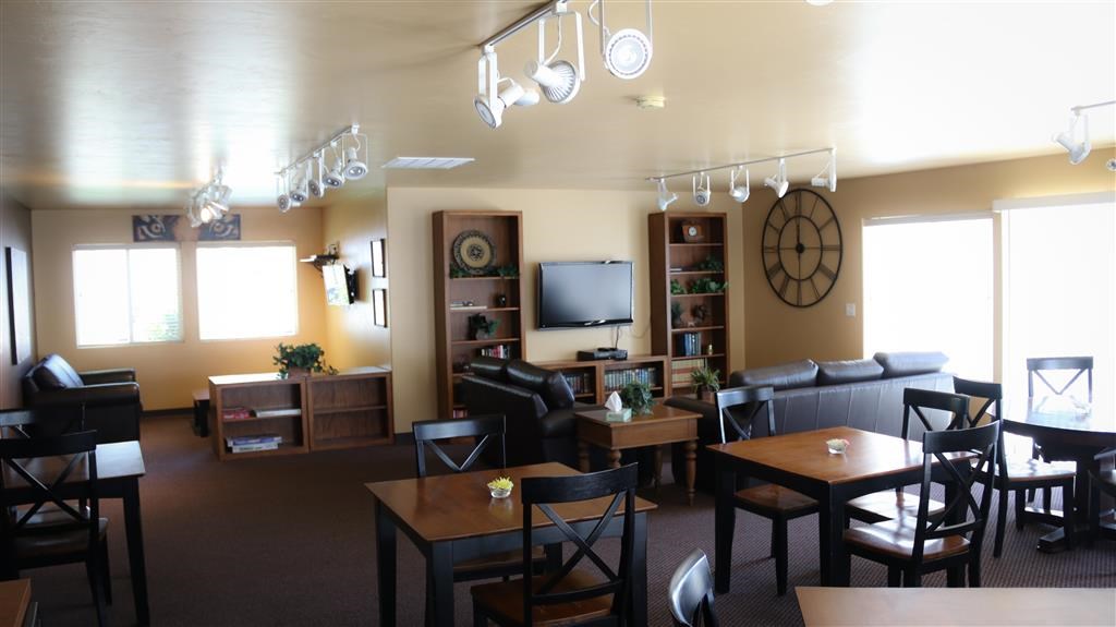 a living room with tables and chairs and a clock on the wall