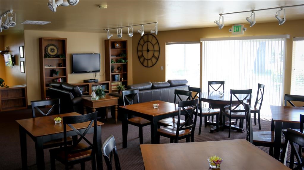 a living room with tables and chairs and a clock on the wall