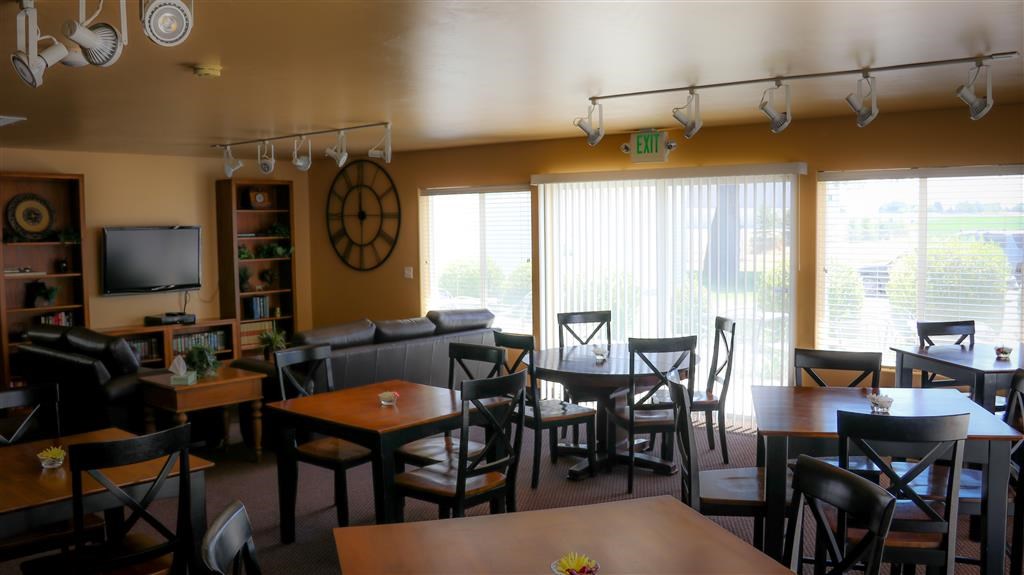 a restaurant with tables and chairs and a clock on the wall