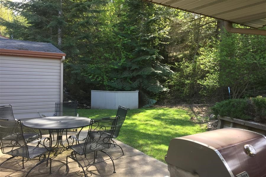 a patio with a table and chairs and a grill