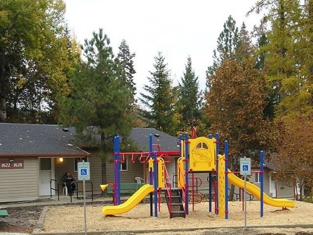 a colorful playground in a park near a building