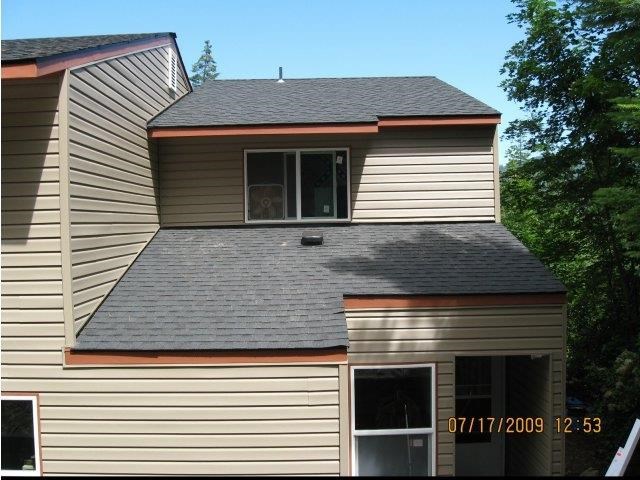 a white house with a gray roof and a window