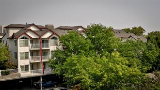 a large apartment building with trees in front of it