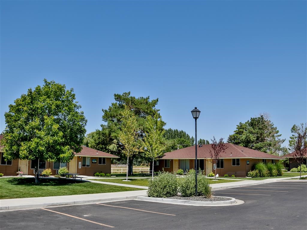 an empty parking lot in front of a yellow house