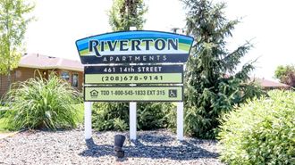 a sign for riverton apartments in front of a house