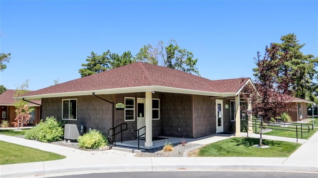 a brown building with a porch and stairs