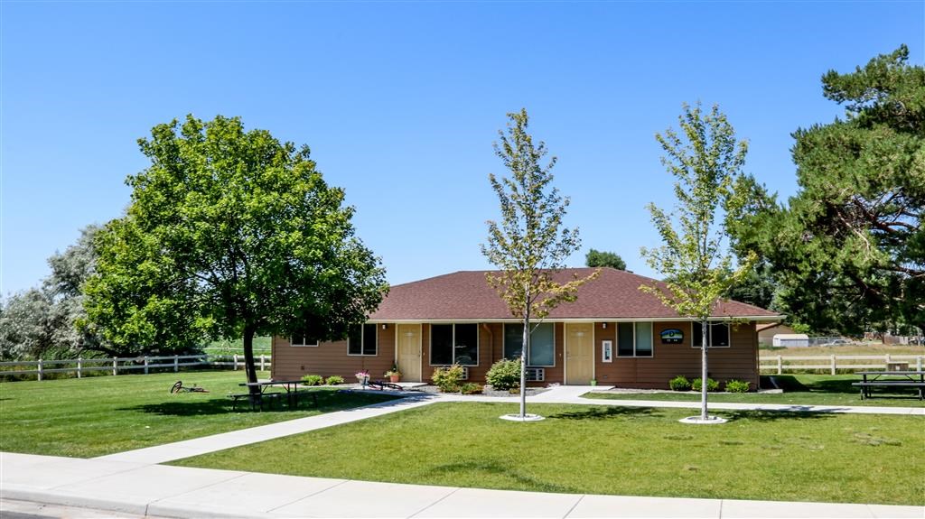 a brown house with a yard and trees