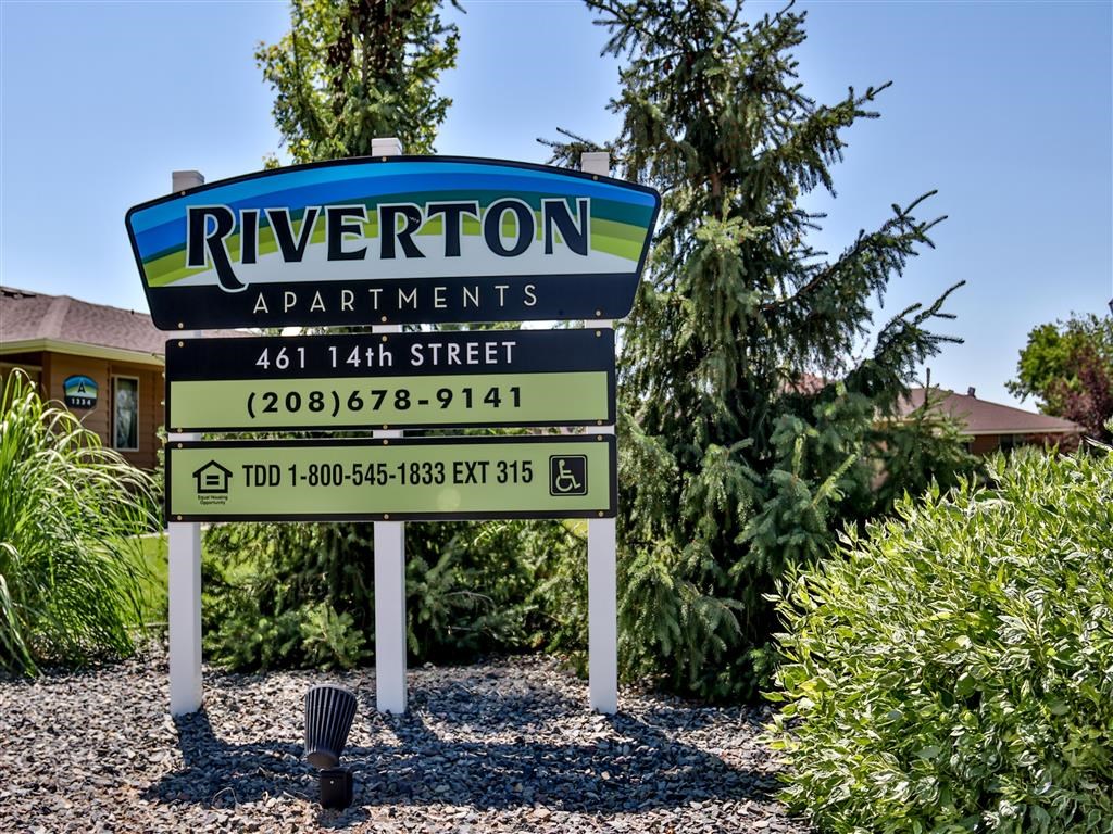 a sign for riverton apartments is shown in front of trees