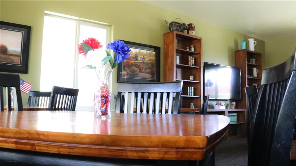 a dining room table with a vase of flowers on it