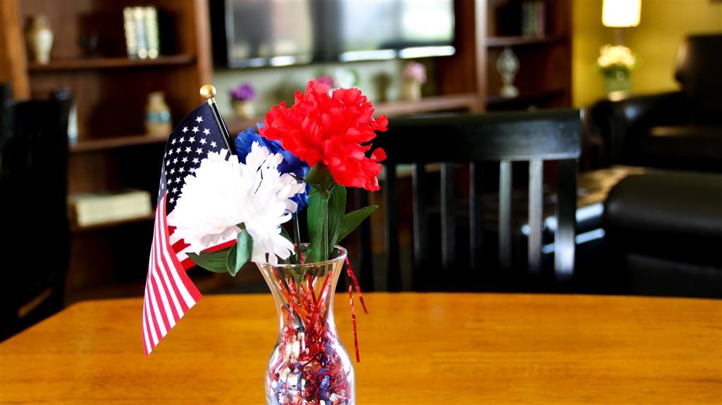a vase with red white and blue flowers and an flag