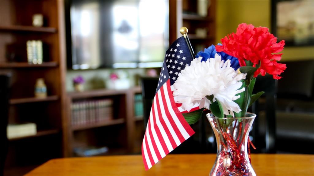 a vase with flowers and an flag on a table