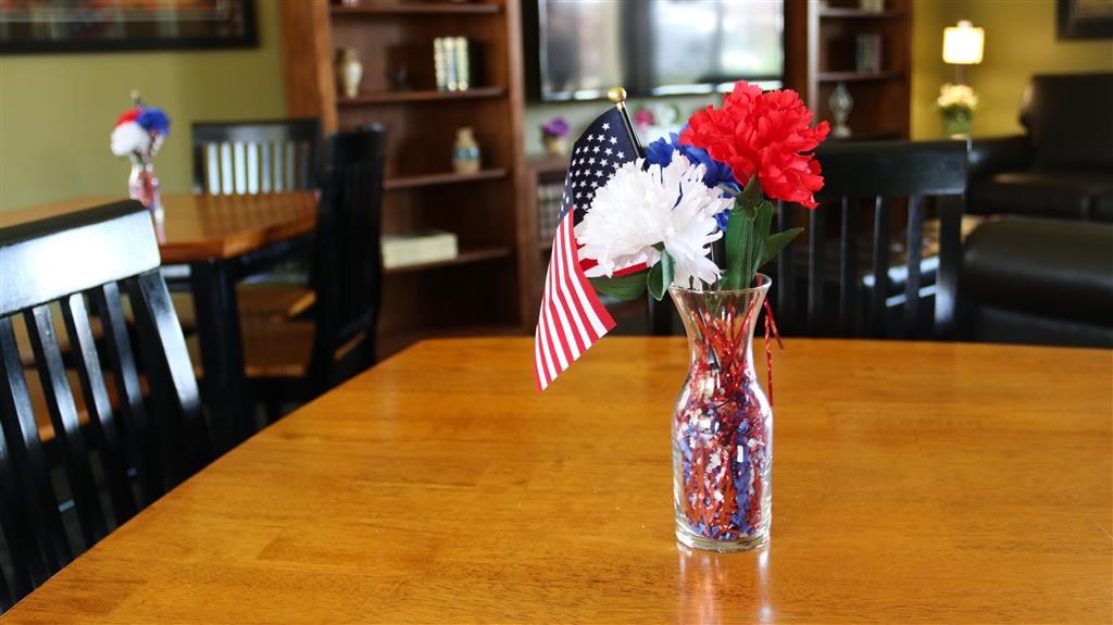 a vase with flowers and an flag on a table