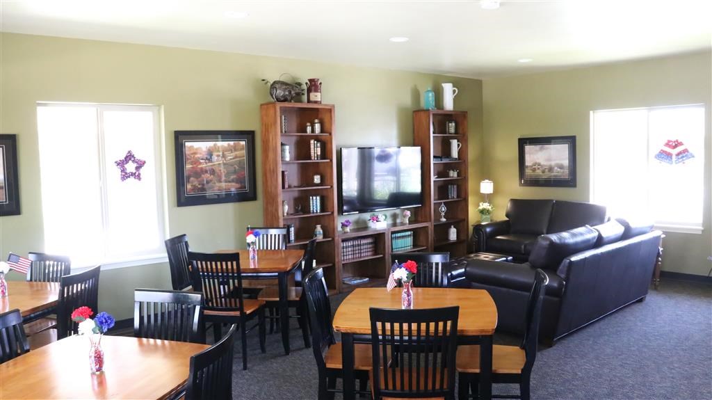 a living room with tables and chairs and a television